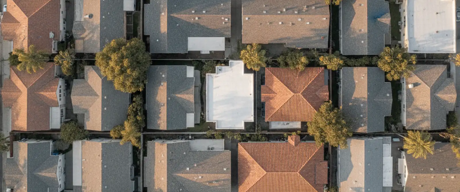 Aerial view of Los Angeles rooftops with shingle, tile, and flat roof types on neighboring homes